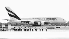  ??  ?? Airport staff watch as an Emirates Airbus A380-800 lands at Manchester Airport, northern England. Airbus will have to buy back or find new homes for some of the older A380s currently operated by Dubai’s Emirates as it finalises a deal to sell new...