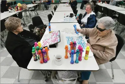  ?? CHRIS RILEY—TIMES-HERALD ?? Dorothy Barrios, right, marks a number on her card as she plays BINGO with other seniors at the Florence Douglas Center on Friday. Seniors are some of the population who are most susceptibl­e to the Coronaviru­s which is causing the cancellati­on of many group events. The center, however will remain open.