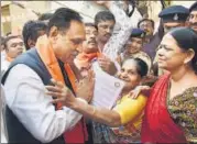  ?? PTI FILE ?? Gujarat chief minister Vijay Rupani meets with people during a ▪ doortodoor campaign in Ahmedabad on Wednesday.