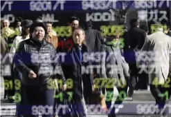  ?? — AP ?? TOKYO: People are reflected on an electronic stock indicator of a securities firm.