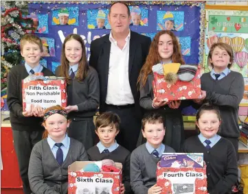 ??  ?? Principal Denis Murray with pupils representi­ng 3rd, 4th, 5th and 6th Classes, who are pictured with some of the items they brought in for the Christmas Charity Collection at the School.