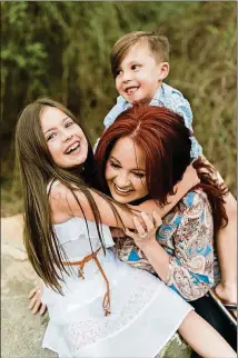  ?? CONTRIBUTE­D ?? Amy Corn enjoys her children during happier times. Corn suffered from postpartum depression after the birth of both children.