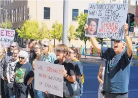  ?? ADOLPHE PIERRE-LOUIS/JOURNAL ?? Patty Kuming, center, and her husband, Bob Kuming, hold signs during a demonstrat­ion at Fourth and Gold in Downtown Albuquerqu­e on Friday afternoon.