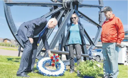  ?? SHARON MONTGOMERY-DUPE/CAPE BRETON POST ?? Cape Breton Regional Municipali­ty District 9 Coun. George MacDonald, left, lays a wreath at the Miners’ Memorial Park in Glace Bay, accompanie­d by Mary Pat Mombourque­tte, executive director of the Cape Breton Miners’ Museum, and Dan Jimmy White of Glace Bay, a 28-year former miner, to commemorat­e Davis Day. The annual ceremonies were cancelled this year due to the COVID-19 pandemic.