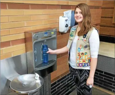  ?? CHAD FELTON — THE NEWS-HERALD ?? Perry High School senior Rebecca Weggel in front of her Girl Scout Gold Award project. The water filling station serves to help eliminate the excessive usage of disposable plastic water bottles.