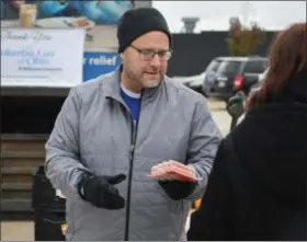  ?? ERIC BONZAR — THE MORNING JOURNAL ?? Columbia Gas Operations Manager Dave Musser hands out packages of frozen hot dogs during Second Harvest Food Bank of North Central Ohio’s monthly, mobile food pantry, held at El Centro de Servicios Sociales Inc., in Lorain, Nov. 16. Volunteers from...