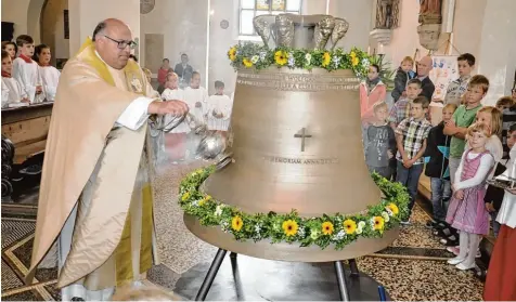  ?? Fotos: Helmut Bissinger ?? Dekan Robert Neuner weihte die neue Glocke. Die hat Franz Deibler gestiftet – und zwar aus einem besonderen Grund.