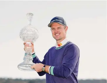  ?? Ezra Shaw/Getty Images ?? Justin Rose of England celebrates with the trophy on the 18th green after winning the continuati­on of the final round of the AT&T Pebble Beach Pro-Am at Pebble Beach Golf Links on FebMonday in Pebble Beach, Calif.