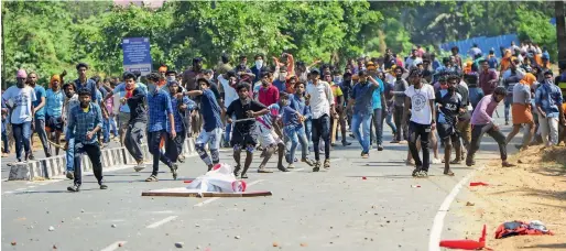  ?? PTI ?? BJP workers hurl stones at the CPI office during their protest against the entry of two women into the Sabarimala temple, in Palakkad, on Thursday. —