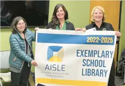  ?? OLCHS ?? Bette Zablocki, from left, from the Associatio­n of Illinois School Library Educators, presents an Exemplary School Library banner to media specialist­s Eileen Wholley and Jennifer Sidlow, of Oak Lawn Community High School. The school library was one of six in the state to earn the honor, including two others in the Southland.
