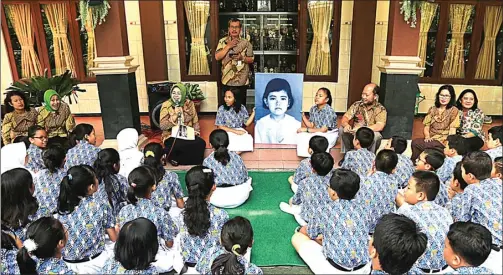  ?? DAMIANUS BRAM/JAWA POS RADAR SOLO ?? MANTAN MURID: Kepala SDN Mangkubume­n Kidul No 16 Surakarta Siti Rahmiyati mengenalka­n sosok Kahiyang lewat foto kepada murid-murid kemarin.