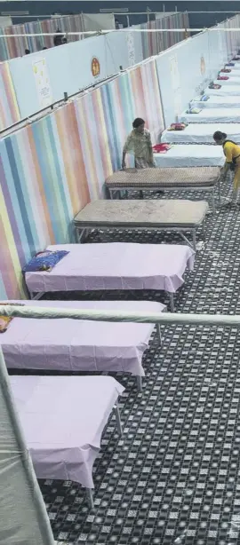  ??  ?? 0 Workers arrange beds at a Covid-19 treatment facility set up at an indoor stadium in Gauhati, India. India now has more than 15 million coronaviru­s infections