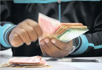  ?? PHOTO: BLOOMBERG ?? Counting the money at the Forex department inside an FNB branch in Johannesbu­rg. Our first order of business is to reaffirm our commitment to maintain fiscal consolidat­ion and keep this firmly on track, maintains the writer.