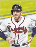  ?? Tony Gutierrez The Associated Press file ?? First baseman Freddie Freeman won’t be reporting with the Atlanta Braves’ position players Tuesday after the birth of his twin sons.