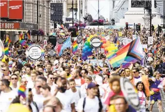  ?? JAMES MANNING AP PHOTOS ?? People take part in Pride festivites Saturday in London to mark the 50th anniversar­y of the city’s Pride parade.