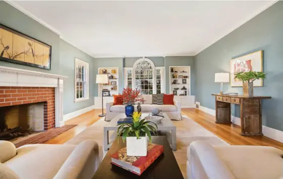  ?? OPENHOMESP­HOTOGRAPHY ?? Above: A fireplace warms a living room lined with wide-plank wood flooring. Below: The Berkeley home includes an office/study with built-in shelving and a fireplace.