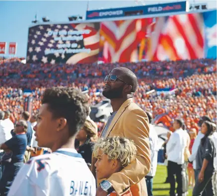  ?? Joe Amon, The Denver Post ?? Champ Bailey, wearing his gold Pro Football Hall of Fame jacket, is joined by sons Jace, left, and Brayden on Sunday before receiving his ring for joining the Broncos’ Ring of Fame.