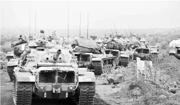  ?? — Reuters photo ?? Turkish tanks and soldiers near the town of Hassa on the Turkish-Syrian border in Hatay province.