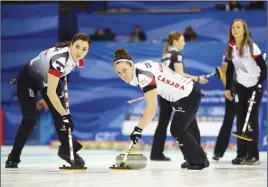  ?? AP PHoTo ?? Canada’s Lisa Weagle, left, and Joanne Courtney, centre, sweep as Rachel Homan watches during their match against Russia yesterday.