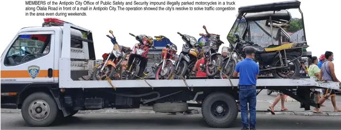  ?? PHOTOGRAPH COURTESY OF PNA ?? MEMBERS of the Antipolo City Office of Public Safety and Security impound illegally parked motorcycle­s in a truck along Olalia Road in front of a mall in Antipolo City. The operation showed the city’s resolve to solve traffic congestion in the area even during weekends.