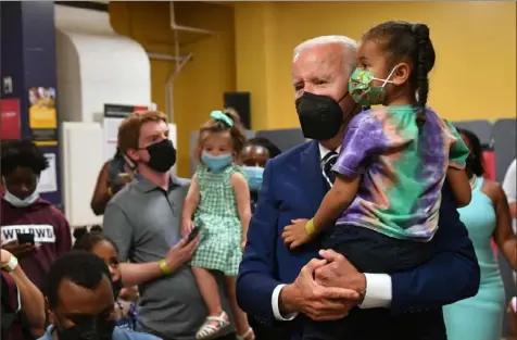  ?? Nicholas Kamm/AFP via Getty Images ?? President Joe Biden greets children during a visit to a COVID-19 vaccinatio­n clinic Tuesday at the Church of the Holy Communion in Washington.