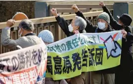  ?? EUGENE HOSHIKO/AP ?? Protesters rally Wednesday outside the Tokyo High Court in Tokyo, where three former utility executives were cleared of negligence in the 2011 Fukushima disaster.