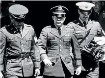  ??  ?? Flanked by two military policemen carrying his personal belongings, Lieutenant William L Calley Jr, of Miami, Florida, leaves court at Fort Benning, Georgia after he was sentenced to life imprisonme­nt for his role in the massacre at My Lai.