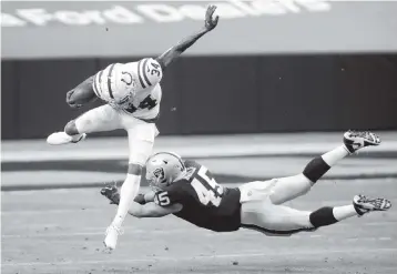  ?? ISAAC BREKKEN AP ?? Colts returner Isaiah Rodgers jumps over Raiders fullback Alec Ingold on a 31-yard kick return in the first half in Las Vegas. The Colts are now closing in on their second playoff berth in three years and first with QB Philip Rivers.