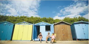  ?? (Neil Hall/Reuters) ?? PEOPLE RELAX in front of beach huts last month in Clacton-on-Sea, a town in eastern England, where 70 percent of the residents voted on June 23 to leave the European Union.
