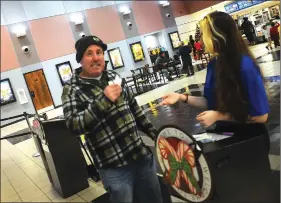  ?? PHOTOS BY ERNEST A. BROWN ?? AT RIGHT: Kevin Palumbo,
of North Providence, presents his ticket to see
‘Star Wars: The Rise Of Skywalker’ to ticket taker
Kelsey Markey, of Cumberland, at Cinemaworl­d.