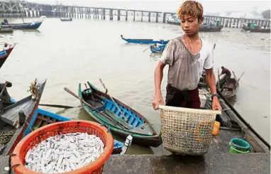  ??  ?? All in a day’s work: A Rohingya boy working at the Myanmar port of Sittwe. — Reuters