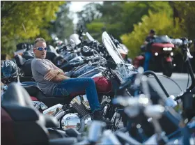  ?? NWA Democrat-Gazette/ANDY SHUPE ?? Maurice LeBeau of Springdale takes a break Saturday on his motorcycle parked on School Avenue.