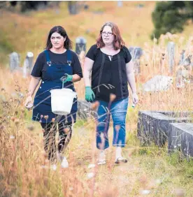  ?? Photo / Jason Oxenham ?? Pania Hall (left) and Kelly Reichardt, part of the Friends of Waikumete charity, clean graves at the cemetery in Glen Eden.