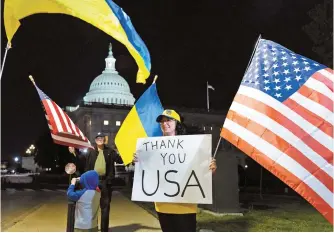  ?? EPA-Yonhap ?? Supporters of Ukraine hold flags outside the U.S. Capitol Building after the Senate passed the $95 billion national security supplement­al that includes aid to Israel, Ukraine and Taiwan on Capitol Hill in Washington, D.C., Tuesday.