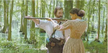  ??  ?? TAKE AIM: Newt Knight (Matthew McConaughe­y) teaches escaped slave Rachel (Gugu Mbatha-Raw) to fire a gun in ‘Free State of Jones.’