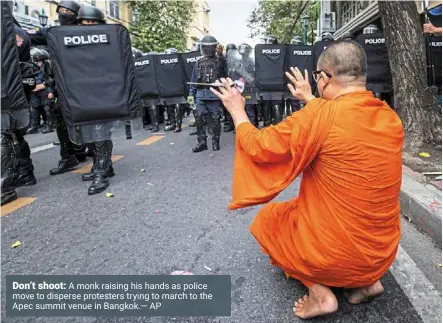  ?? ?? Don’t shoot: a monk raising his hands as police move to disperse protesters trying to march to the apec summit venue in bangkok.— ap