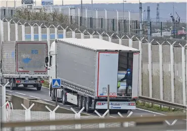  ?? (AFP) ?? This file photo shows a migrant standing in the back of a truck bound for Britain while traffic stopped upon waiting to board shuttles at the entrance to the Channel Tunnel site, in Calais, northern France, on November 19