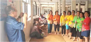  ??  ?? Uggah (left) takes a snapshot of the women from Rh Linggie who recently completed their six-month embroidery course, during a walkabout there.