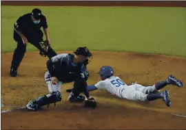  ?? SUE OGROCKI — THE ASSOCIATED PRESS ?? The Dodgers’ Mookie Betts scores past Tampa Bay catcher Mike Zunino to give L.A. a 2-1 lead in the sixth inning in Game 6. The Dodgers went on to a 3-1 victory for the title.