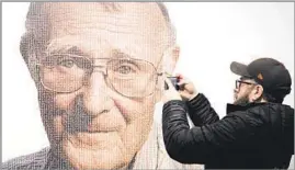  ?? Ola Torkelsson Associated Press ?? A REVOLUTION­ARY IDEA A visitor photograph­s a portrait of Ingvar Kamprad at a Swedish museum. His firm produced furniture for the masses that was affordable and easy to transport.