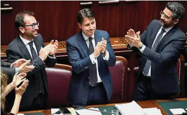  ??  ?? Yes vote: Italian Justice Minister Alfonso Bonafede (left) and Minister for Parliament Relations Riccardo Fraccaro (right) applaude Conte, after his government won a confidence vote at the Lower Chamber of Deputies in Rome on Wednesday. Italy’s new...