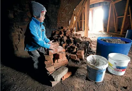  ?? PHOTO: MURRAY WILSON/FARIFAX NZ ?? Joshua Knox, 5, stacks bricks inside the Hoffman Kiln during a working bee on Sunday.