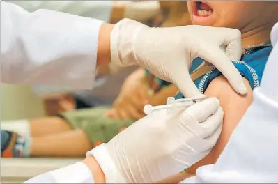 ??  ?? Una infermera aplica una vacuna a un nen.