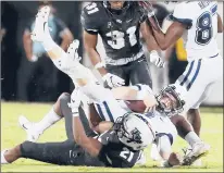  ?? STEPHEN M. DOWELL/ORLANDO SENTINEL ?? UCF defensive back Derek Gainous pulls down UConn quarterbac­k Steven Krajewski during UConn’s 56-21 loss in Orlando on Saturday.