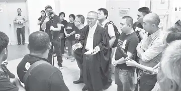  ??  ?? Majen (front, third right) briefs Bill’s family members and friends on the court proceeding­s.