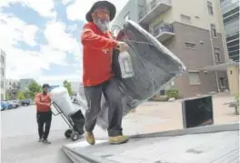  ?? Jeremy Papasso, Daily Camera ?? Profession­al Moving Services employees Mike Tabev, right, and Mark Galemov last week load a truck with belongings from a renter at The Peloton apartments in Boulder.