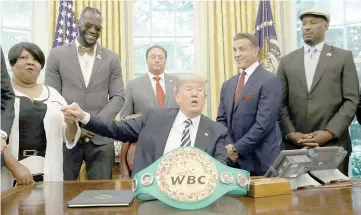  ?? — Reuters photo ?? Donald Trump clasps hands with Linda Haywood, great great niece of the first black heavyweigh­t champion Jack Johnson, after the US President signed a pardon for Johnson the White House in Washington.