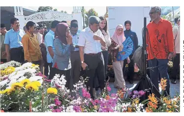  ?? — Bernama ?? In full bloom: Sultan Sharafuddi­n (centre) with Tengku Permaisuri Norashikin visiting the Putrajaya Flower and Royal Garden Festival as Wan Azizah (with blue fan) looks on.