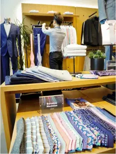  ?? BEBETO MATTHEWS/AP ?? Sean Do, lead guide at Bonobos’ Guideshop, arranges clothing at the showroom in New York’s Financial District.