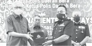  ?? — Gambar Bernama ?? SERAH: Ismail Sabri (kiri) menyerahka­n surat arahan pertukaran dan pemakaian pangkat kepada Ketua Polis Daerah Bera Mansor Samsudin (dua kanan) pada Upacara Pemakaian Pangkat Ketua Polis dan Timbalan Ketua Polis Daerah Bera dekat Bera, semalam.